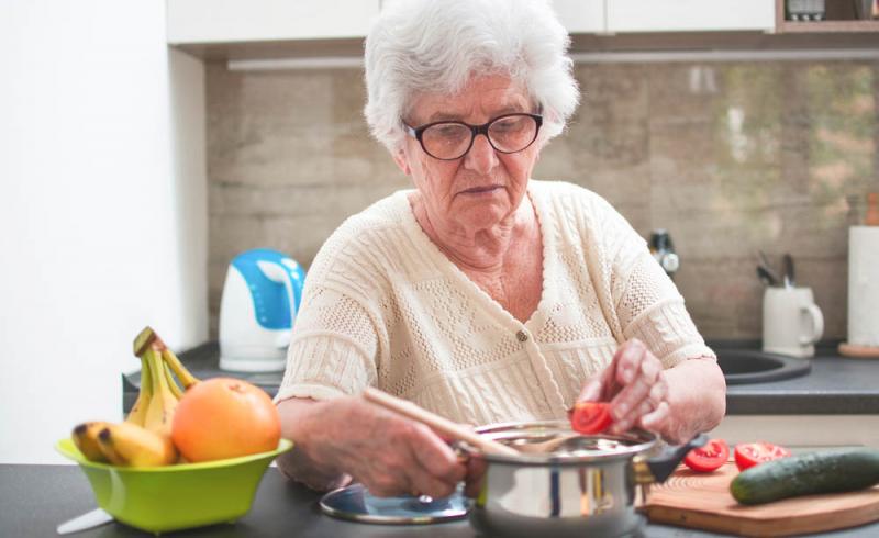 Fotografía de una mujer mayor cocinando