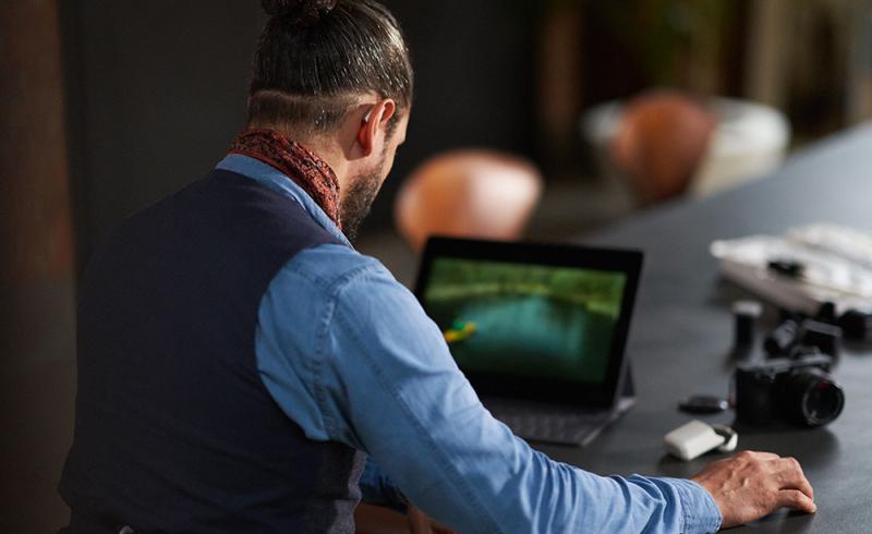 Un hombre utiliza los audífonos Styletto Connect mientras maneja un ordenador portátil