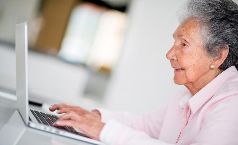 Una mujer mayor realiza trámites con la Administración Pública a través de un ordenador