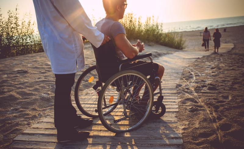 Un joven en silla de ruedas accede a una playa