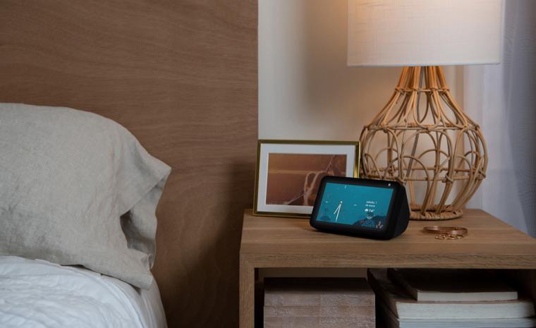 Imagen comercial de un Echo Show 5 sobre una mesilla junto a otros objetos