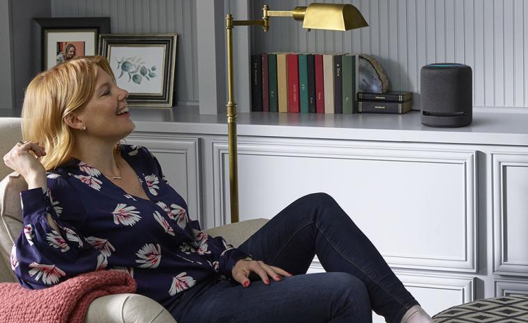 Una mujer utiliza un Echo Studio sentada en su sal&oacute;n
