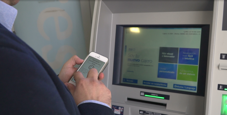 Una persona ciega utiliza la aplicaci&oacute;n frente a un cajero de BBVA