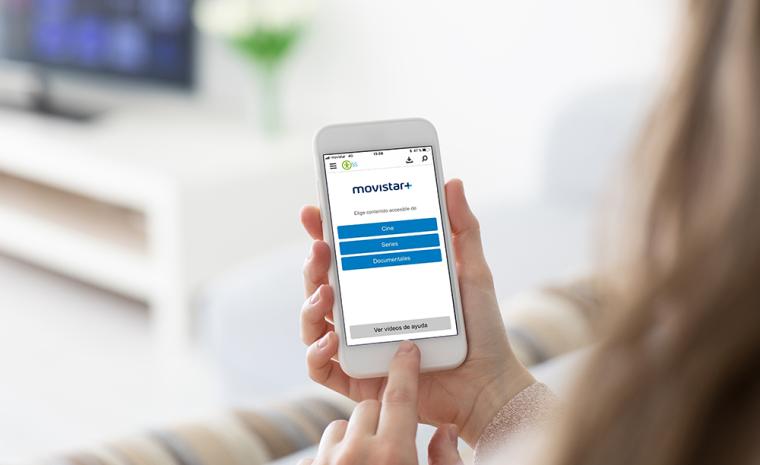 Una mujer utiliza la app de Movistar+ 5S frente al televisor