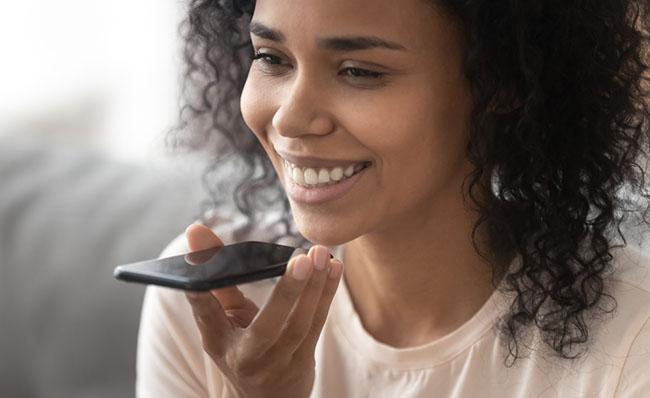 Una mujer utiliza su tel&eacute;fono m&oacute;vil con la voz