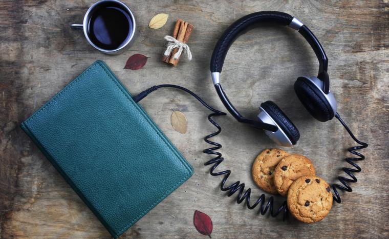 Imagen de un libro al que aparentemente se la han conectado unos auriculares