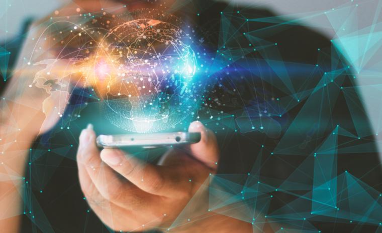 Un montaje fotogr&aacute;fico muestra un mundo digital encima de un smartphone sujetado por una persona