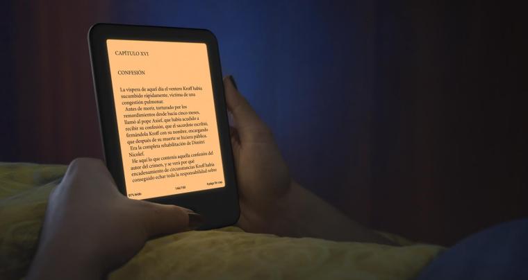 Una persona utiliza su lector Cervantes 4 en la cama con un tono de luz c&aacute;lido