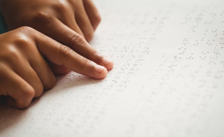 Una persona lee un libro en braille