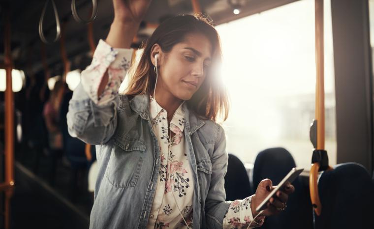 Una joven usa su smartphone en un autob&uacute;s urbano