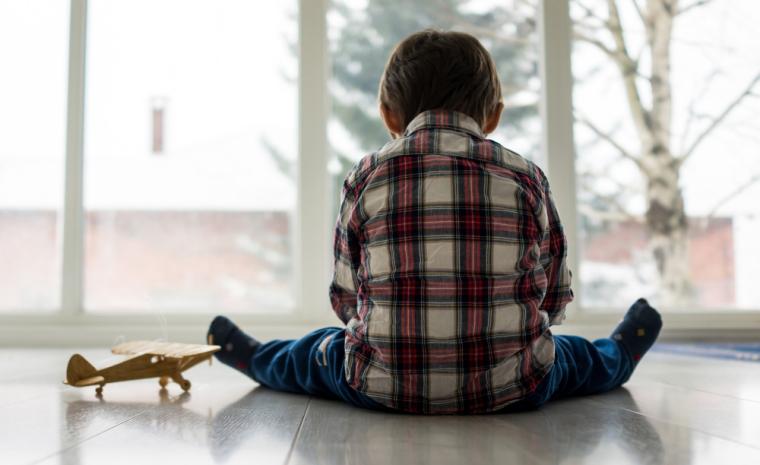 Fotograf&iacute;a de un ni&ntilde;o con TEA sentado frente a una ventana
