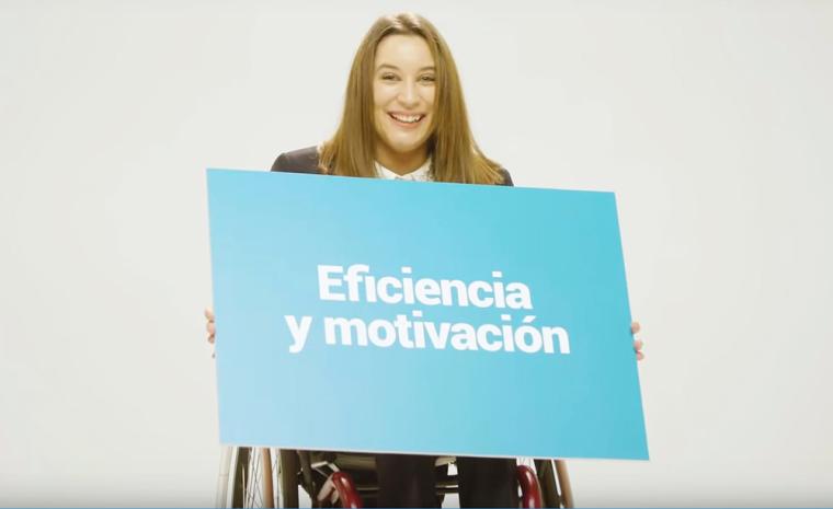 Fotograma del v&iacute;deo elaborado por Cocemfe que muestra a una mujer en silla de ruedas con un cartel
