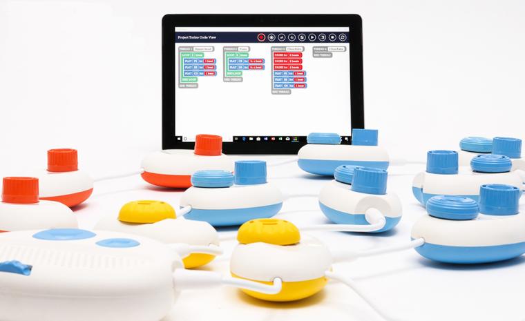 Fotograf&iacute;a de los componentes de Code Jumper y una tableta con el c&oacute;digo de programaci&oacute;n
