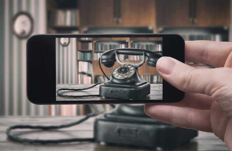 Una persona capta un tel&eacute;fono antiguo con la c&aacute;mara de su smartphone