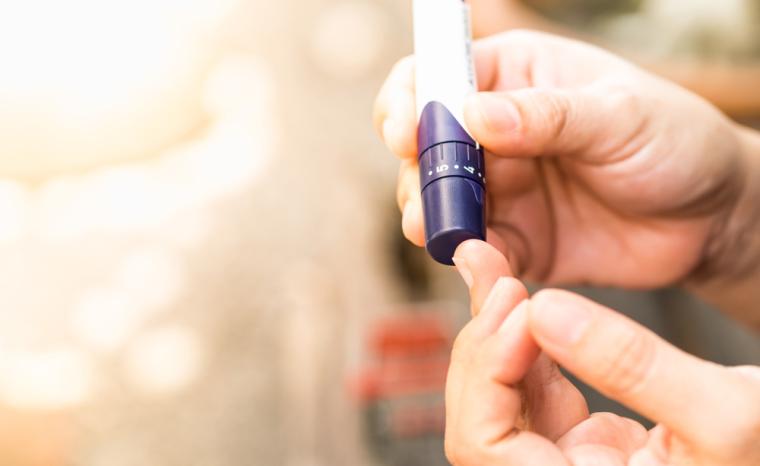 Una persona con diabetes se pincha en un dedo para medir la concentraci&oacute;n de az&uacute;car en sangre