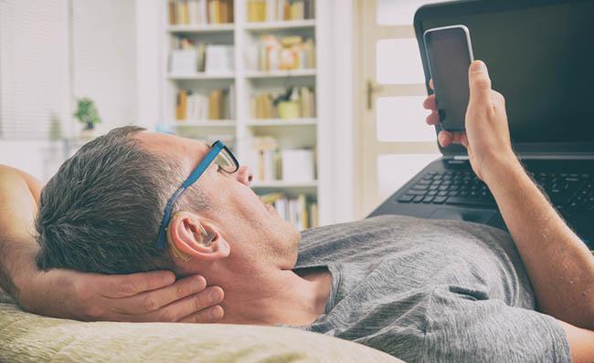 Un hombre con discapacidad auditiva utiliza su tel&eacute;fono m&oacute;vil