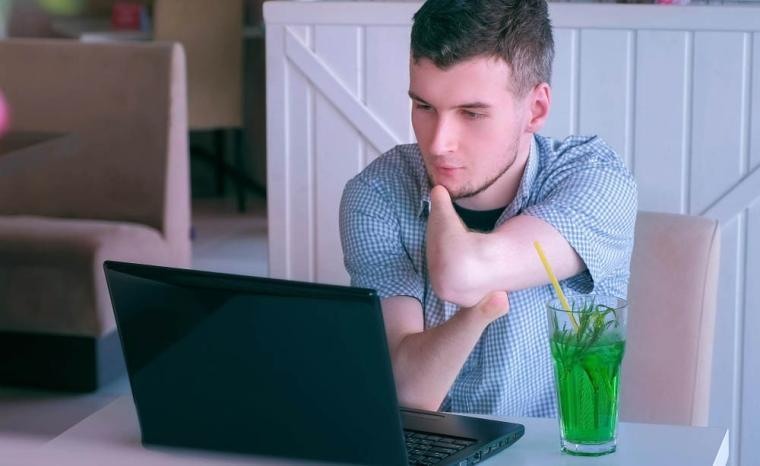 Un joven con discapacidad realiza una videoconferencia a trav&eacute;s de un ordenador portatil