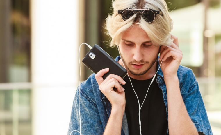 Un joven escucha su tel&eacute;fono m&oacute;vil