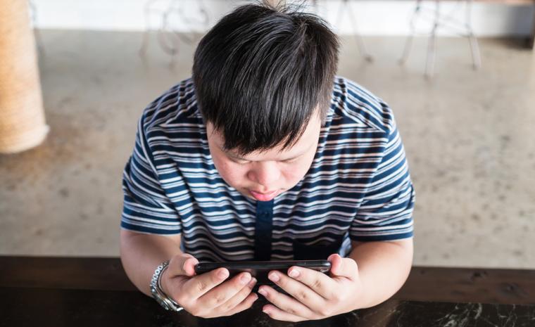 Un joven con s&iacute;ndrome de Down utiliza un smartphone