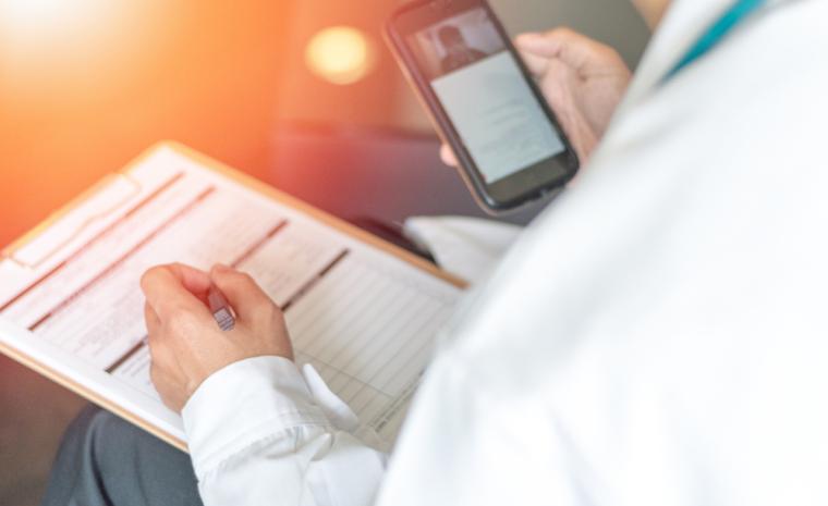 Un doctor utiliza su tel&eacute;fono m&oacute;vil para el seguimiento de un paciente