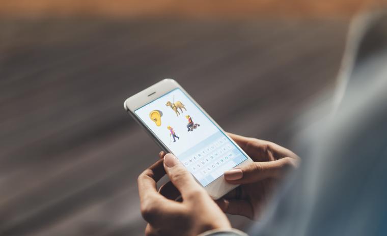 Fotograf&iacute;a de una persona utilizando un smartphone con los nuevos iconos en la pantalla