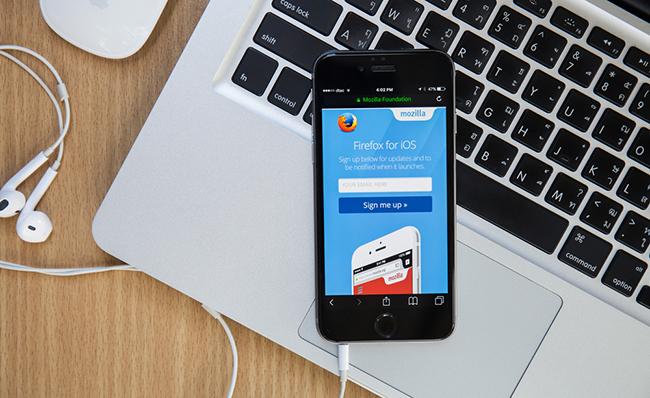 Un smartphone sobre un ordenador port&aacute;til con la versi&oacute;n para iOS de Firefox