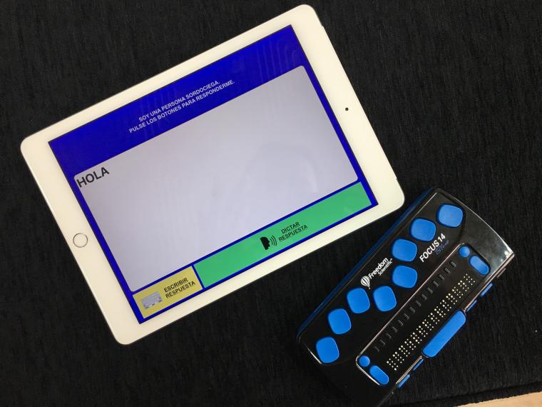 Imagen de una l&iacute;nea de braille y una tableta con la aplicaci&oacute;n Comunicador T&aacute;ctil