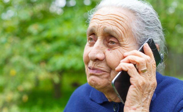 Una mujer mayor utiliza un tel&eacute;fono m&oacute;vil