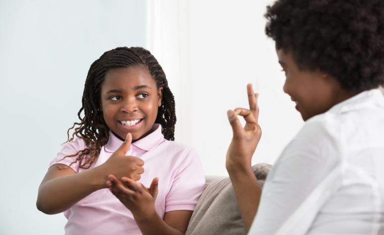Una ni&ntilde;a se comunica por lengua de signos con su madre