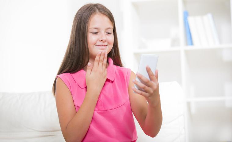 Una joven utiliza la lengua de signos frente a su tel&eacute;fono m&oacute;vil