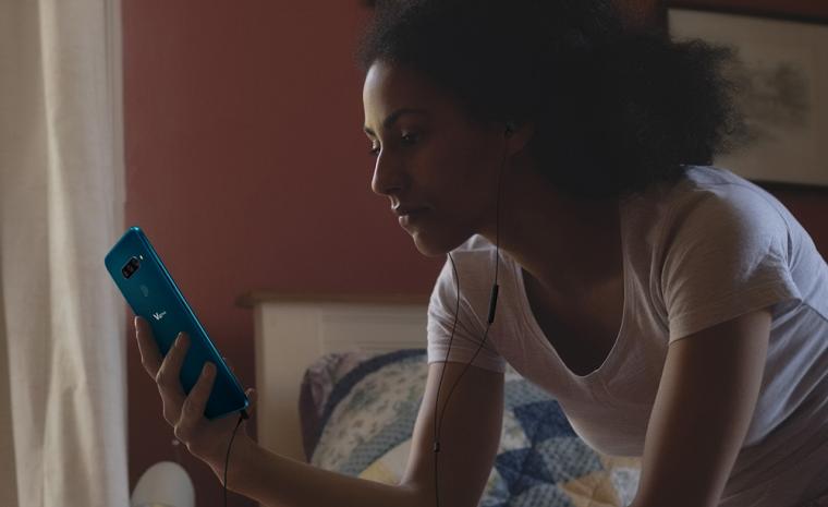 Una mujer utiliza el nuevo LG V40 ThinQ con unos auriculares en los o&iacute;dos