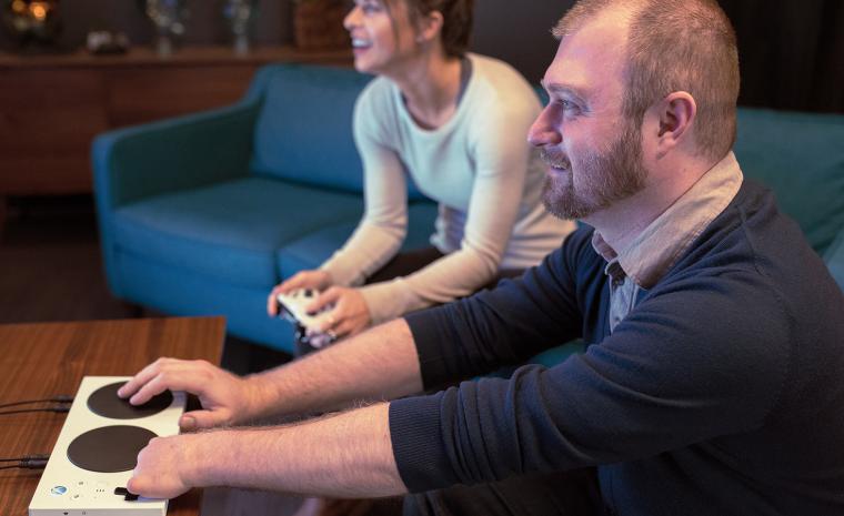 Una persona con discapacidad en un brazo prueba el mando adaptado de Microsoft