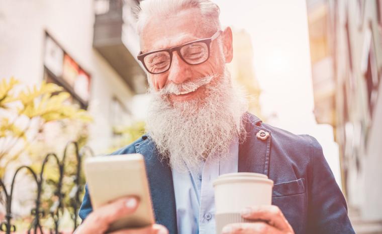 Un hombre mayor utiliza su smartphone.
