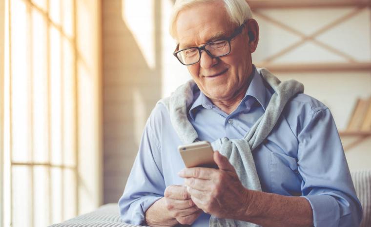 Un hombre mayor utiliza su tel&eacute;fono m&oacute;vil