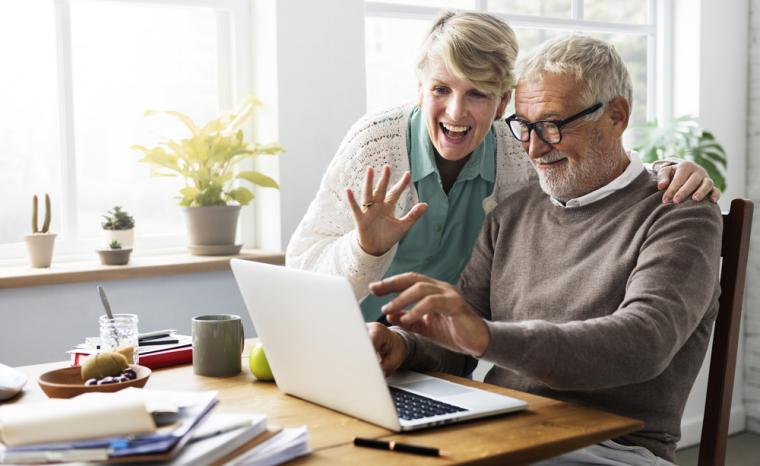 Una pareja de personas mayores utiliza Internet con un ordenador port&aacute;til