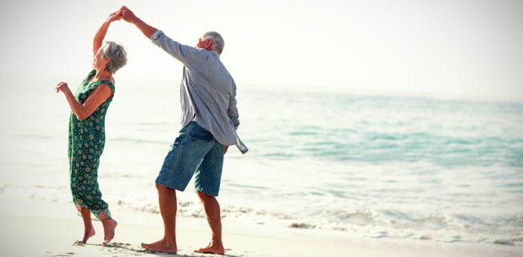 Una pareja de personas mayores disfrutan en la playa