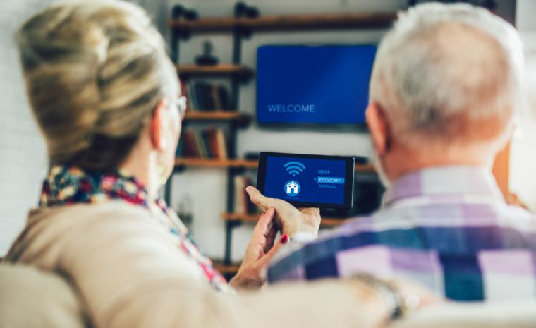 Una pareja de personas mayores utiliza dispositivos de hogares inteligentes