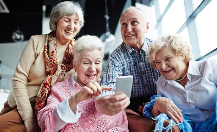 Varias personas mayores utilizan un smartphone