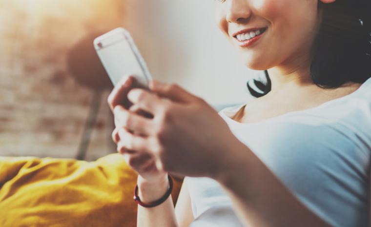 Una joven utiliza su m&oacute;vil para ver la televisi&oacute;n