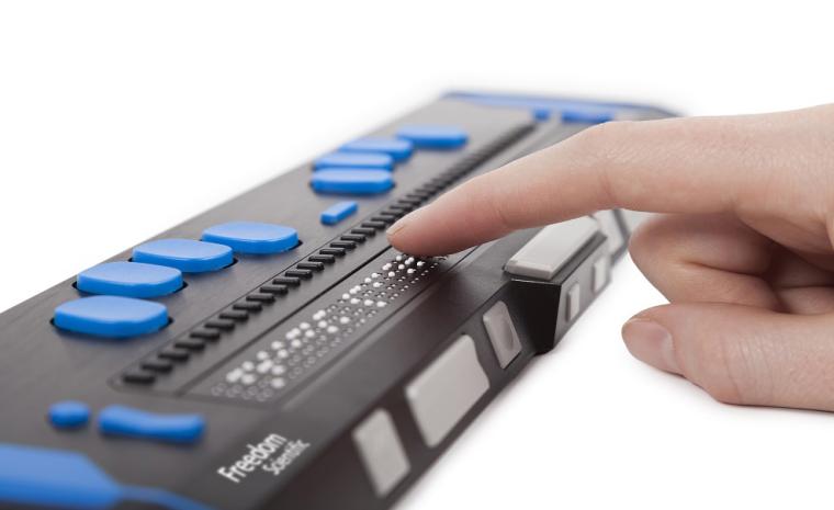 Fotograf&iacute;a de una persona usando una l&iacute;nea braille de Freedom Scientific
