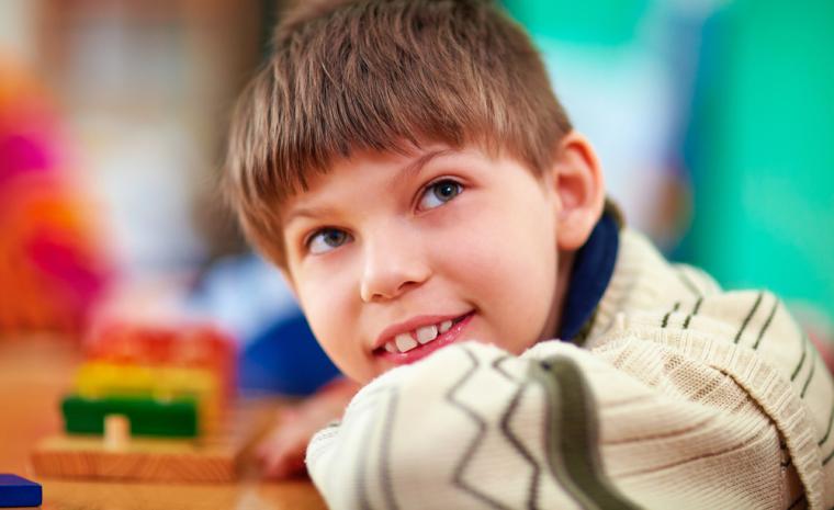 Un ni&ntilde;o con discapacidad juega en una mesa