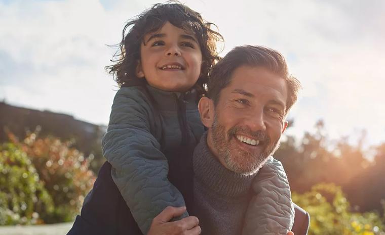 Un hombre utiliza un Oticon OPN S con un ni&ntilde;o en su espalda