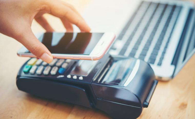 Una persona paga con el m&oacute;vil en un comercio