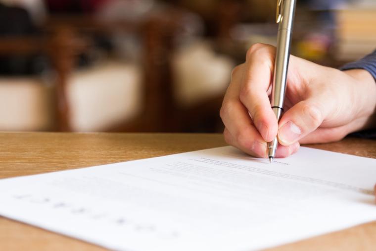 Una persona firmando un documento
