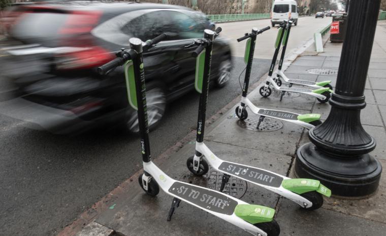 Varios patinetes el&eacute;ctricos aparcados en la acera de una ciudad