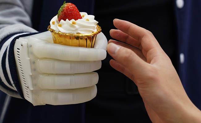 Imagen de la pr&oacute;tesis de mano hinchable cogiendo un pastel