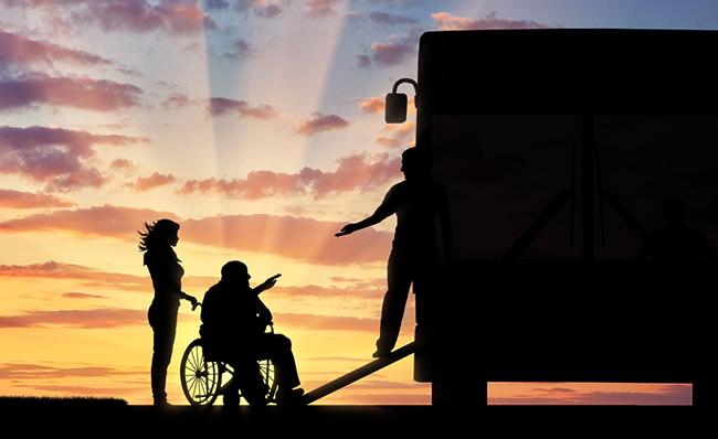 Una persona en silla de ruedas se prepara para subir a un autob&uacute;s a trav&eacute;s de una rampa