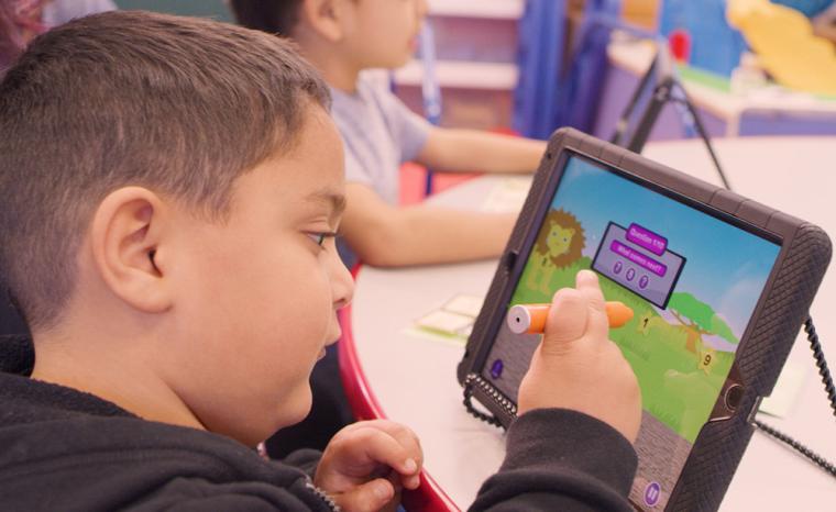 Un ni&ntilde;o utiliza ReadAble Storiez en una tableta en el colegio