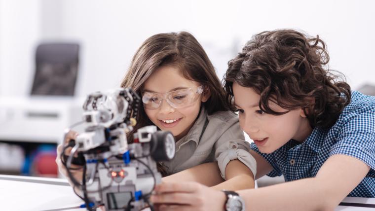 Dos ni&ntilde;os aprenden montando un robot.