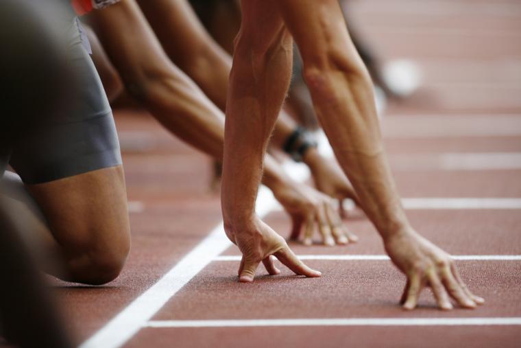 Varios deportistas se preparan para una salida en una prueba de velocidad